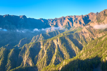 Aerial view of steep volcanic ridges and forested slopes inside Parque Nacional de la Caldera de Taburiente on La Palma, ideal for: nature editorials, adventure travel campaigns and premium wall art.