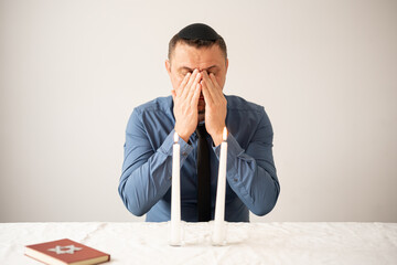 Jewish man praying with Shabbat candles. Shabbat Shalom.