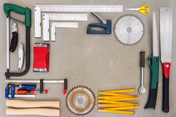 Flat lay of old hand tools on concrete background. Large collection of various rusty tools and bits arranged on concrete.