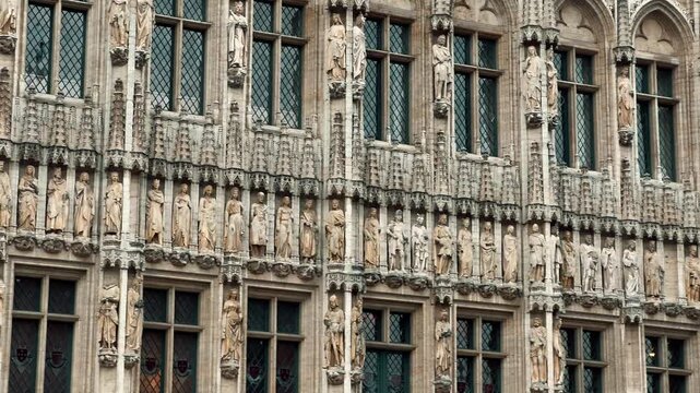Tilt up view of the intricate Neo-Gothic facade and tower of the Brussels City Museum, Maison du Roi, located in the historic Grand Place square in Belgium.

