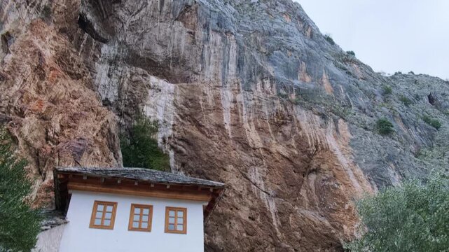 Handheld bottom up panning footage of The Blagaj Tekija, historic Sufi monastery and dervish house built on the cliffs by the Buna river in Mostar, Bosnia and Herzegovina