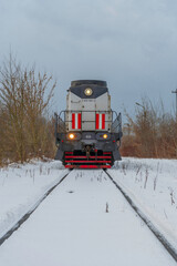 Lokomotywa spalinowa Cargo na zaśnieżonych torach przy Hucie Warszawa, transport kolejowy zimą.