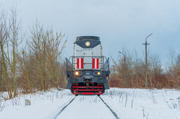 Lokomotywa spalinowa Cargo na zaśnieżonych torach przy Hucie Warszawa, transport kolejowy zimą.