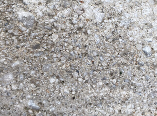 Textured concrete surface with various pebbles and stones visible