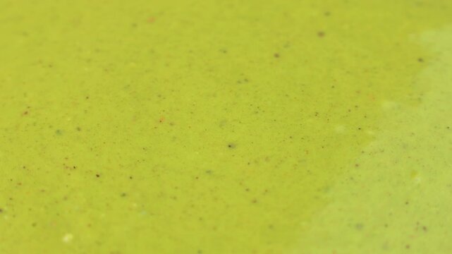 Green homemade pistachio paste texture circle rotation close up