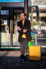 Tourist with a rolling suitcase waiting for a bus