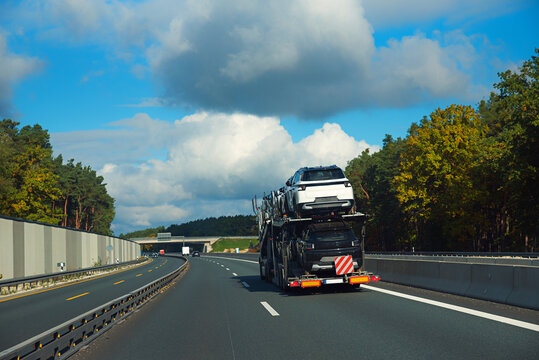 car transporter with 2 rows of new small cars on the trailer, highway germany
