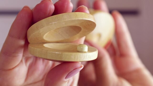 Woman holding in hands and playing wooden Castanets musical instrument