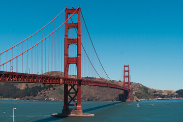 Obraz premium Golden Gate Bridge, a famous landmark, connecting San Francisco and Marin Headlands, standing tall over the blue waters of San Francisco Bay under a clear sky
