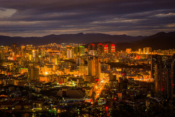 Sunset view of Sanya town with city lights. View from Luhuitou Park on Hainan Island of China.