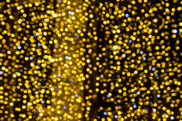 Golden bokeh lights creating sparkling circular glows against dark background, perfect for festive overlays and holiday photography effects. Celebration lighting and atmospheric design themes.