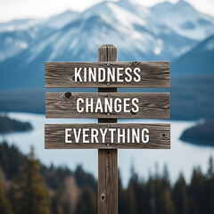 Wooden sign with inspirational quote kindness changes everything in front of scenic landscape