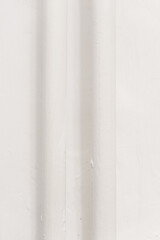 Minimalistyczne, jasne tło w odcieniach bieli i kremu z delikatnymi pionowymi liniami, idealne jako neutralna tekstura lub abstrakcyjne tło.