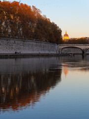 Obraz premium Tiber River with Autumn Trees and St Peter’s Basilica at Sunset