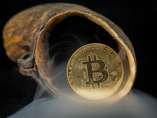 Golden bitcoin coin inside an old animal horn with smoke on dark background.