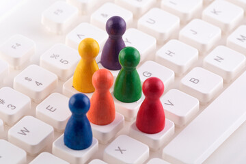 Colorful group of pawn people figures on computer keyboard