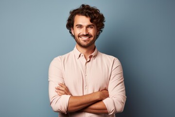 Obraz premium Cheerful young man posing with a beaming smile and folded arms