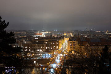 Fototapeta premium City of Prague in the evening during winter season. Illuminated street due to Christmas decoration in the trees of the old town. Beautiful light chains and the Church at the town square.