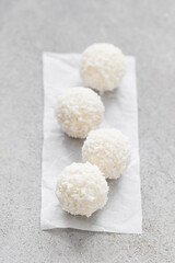 Vegan Coconut dessert candy ball. On paper. On a light background. Close-up	