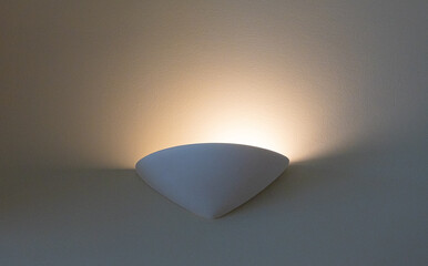 White wall sconce creating ambient light glow