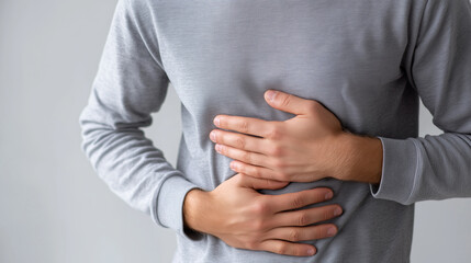 Man holding his stomach in pain, symbolizing abdominal discomfort, illness, and digestive health issues.
