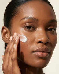 dark skin woman beauty macro shot, woman applying skin care cosmetic, face cream, spf cream, sun protecting factor lotion applying, face mask