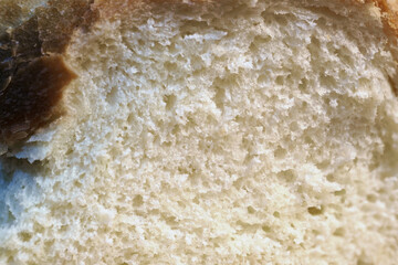 Close-up view of a sliced loaf of white bread with golden-brown crust