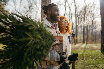 Young couple is packing Christmas tree on the car
