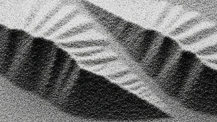Abstract black and white sand ripples with strong shadows creating a striking visual texture.