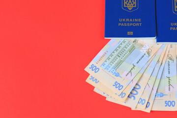 Ukrainian foreign biometric passport with inscription in Ukrainian - Ukraine passport with hryvnia notes on red background.