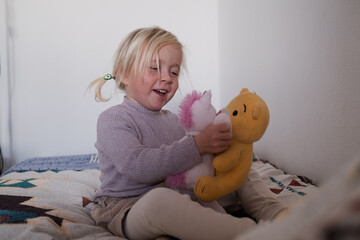 Cute little 4 year old girl playing with plush toys on the playground.