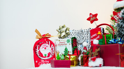 Festive Christmas scene with wrapped presents, Santa decorations, and holiday ornaments set against a bright white background.