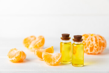 Tangerine essential oil on a wooden table. Bottles of citrus essential oil and sliced ​​fruits....