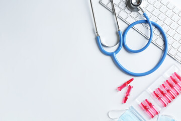 Telehealth. Keyboard, stethoscope, ampoules and medical masks on light table, flat lay. Space for...