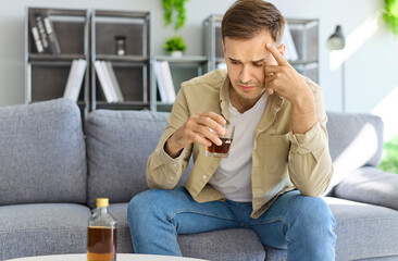 Struggle against alcohol addiction in man with stress and anxiety holding liquor or whiskey glass,...