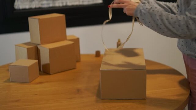 Close-up shot of a small business owner securing a shipment with natural fiber ribbon, focusing on plastic-free packaging solutions.