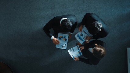Top view of skilled businessman handed out financial paper to manager. Professional marketing team talking about marketing idea while receive and look at stock market investment chart. Directorate.