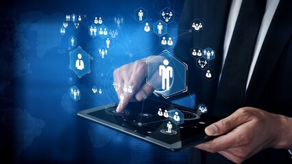Professional analyzing digital person icons on a tablet device with futuristic technology interface showcasing connection and engagement in a modern workplace Gluon.