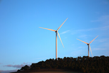 Wind Farm on a Hill Overlooking Rural Landscape and Blue Sky