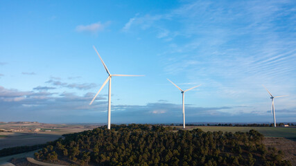 Minimal Wind Turbines Silhouetted on a Hill Beneath Blue Sky