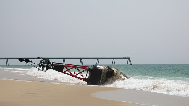 Grande bou&eacute;e de navigation maritime rouge et noire &eacute;chou&eacute;e sur une plage de sable