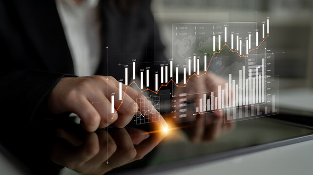 A business professional uses a tablet to analyze financial data, exploring graphs and charts for market trends in a modern office setting. Visualization aids decision-making. Scalp - Powered by Adobe