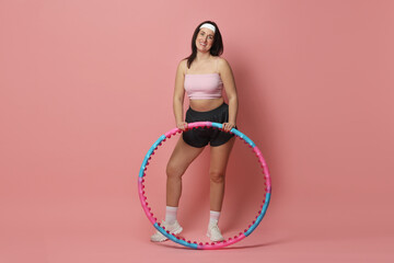 Happy woman with hula hoop on pink background