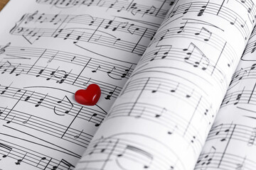 Heart figure on paper sheets with music notes, closeup