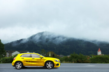 Yellow taxi car driving on country road. Transportation service