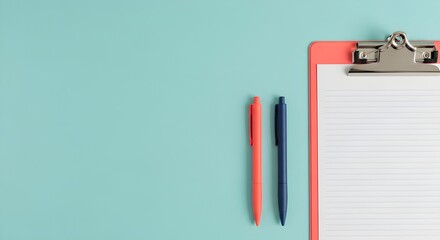 Flat Lay of Orange and Blue Pens Beside a Clipboard on Blue Background