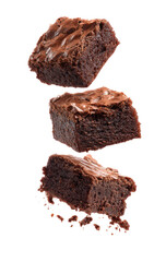 Three brownies stacked in mid-air, slightly angled, with a glossy, dark brown topping and a slightly crumbly texture