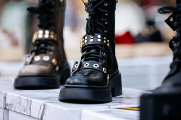 Black leather boots with gold eyelets on display
