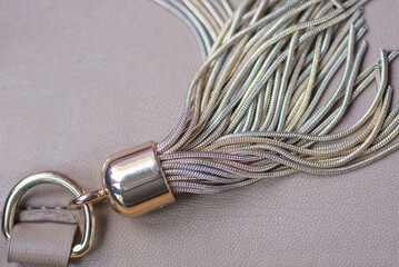 decor of one brown gray tassels on a lace zip made of leather and metal 