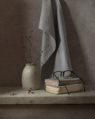 Still life with a gray drapery, a vase, glasses on a light wooden table